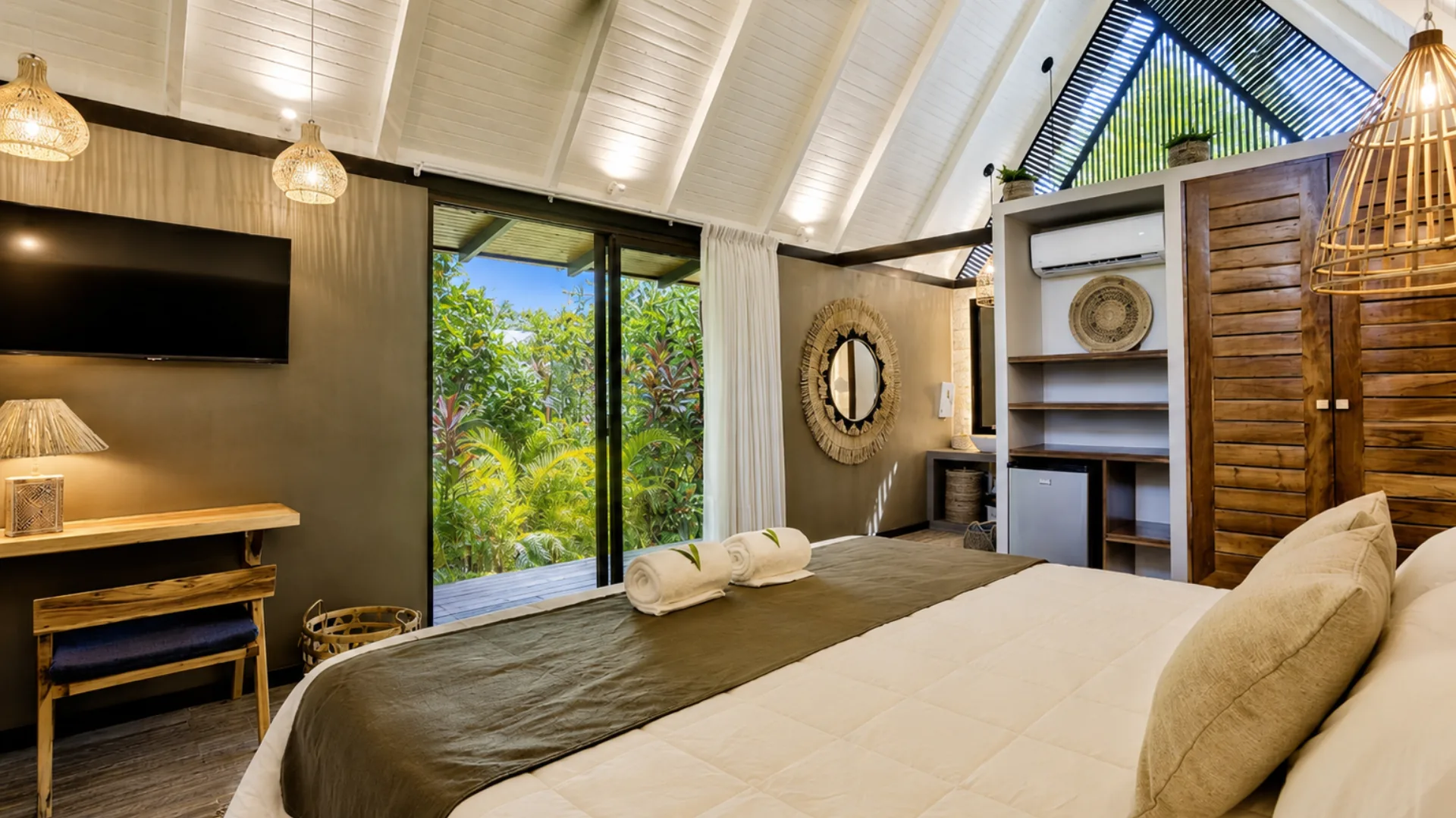 Cama y puertas de vidrio hacia el deck privado del bungalow