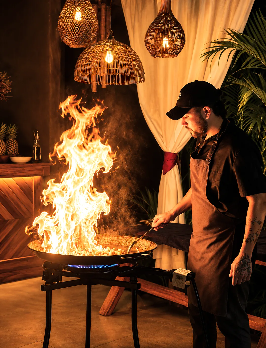 Chef de NUM preparando una paella al fuego durante una cena especial
