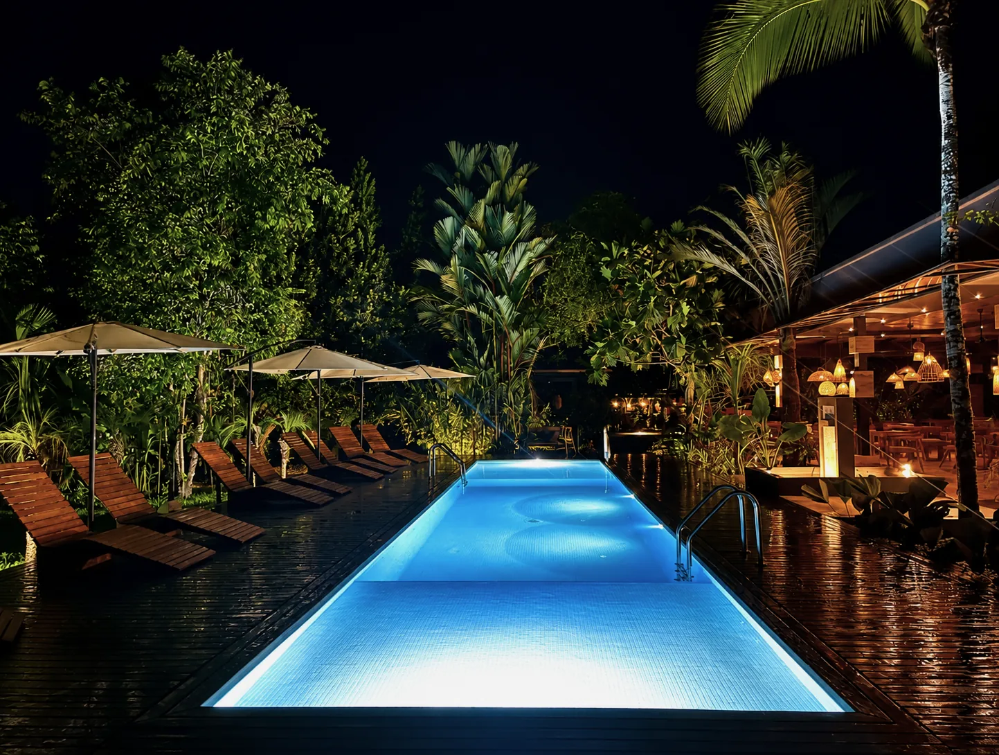 Piscina principal y NUM Restaurant iluminados por la noche